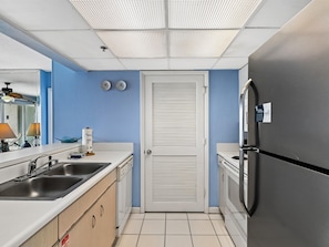 Una cocina compacta con pileta, estufa y refrigerador.