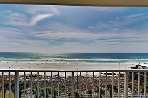 A beach view from a balcony with a railing, ocean, and distant shoreline. - Summit Beach Resort #604 | Beach Service Included! (Panama City Beach)