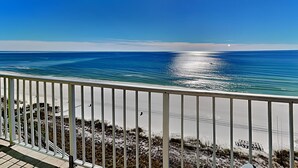 Een balkon met uitzicht op zee en strand.