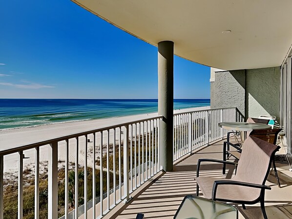 Een balkon met uitzicht op het strand en de oceaan.