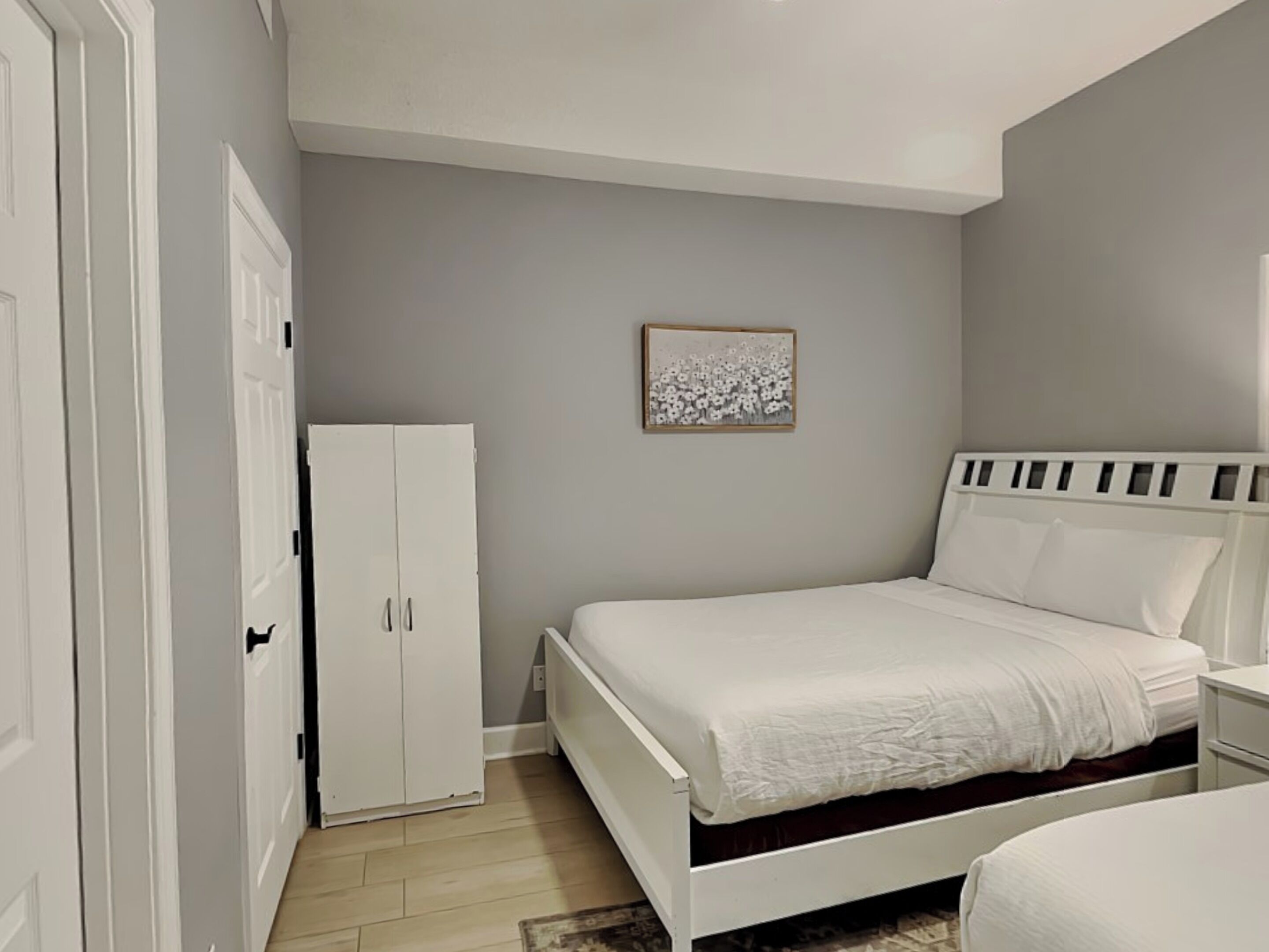 Une chambre à coucher avec un lit, une armoire et une table de chevet.