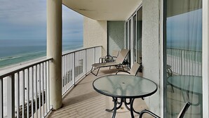 A balcony with a glass table and chairs, overlooking the beach. - Long Beach III #905 | Incredible Gulf Views (Panama City Beach)