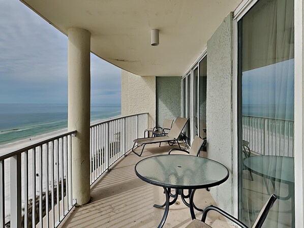 A balcony with a glass table and chairs, overlooking the beach. - Long Beach III #905 | Incredible Gulf Views (Panama City Beach)