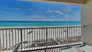 A balcony with a view of a beach and ocean. - Majestic Beach Towers II #707 | Gulf Front + Resort Amenities (Panama City Beach)