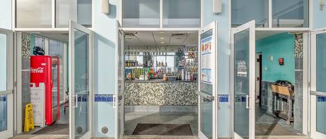 A bar with a tiled backsplash and a Coca-Cola refrigerator outside.