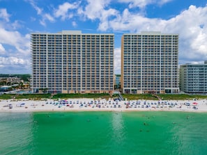 A beachfront hotel with multiple high-rise buildings, a sandy beach, and clear turquoise waters. - Majestic Beach Towers I #1410 | Gulf Front + Amenities (Panama City Beach)