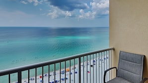 Un balcon avec vue sur une plage et l’océan.