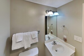 A bathroom with a white sink, a mirror, and two white towels hanging on a rack. - Majestic Beach Towers I #1608 | Gulf Front + Amenities (Panama City Beach)