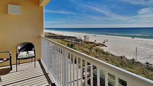 Un balcon donnant sur une plage, une chaise et une petite table.