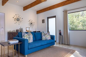 Deluxe Room | Living area | 65-inch flat-screen TV with digital channels, TV, video-game console - Oase by 7 Star Lodges - Greater Kruger Private 530ha Reserve (Hoedspruit)