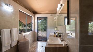 A modern bathroom with a large window, a sink, and a mirror.