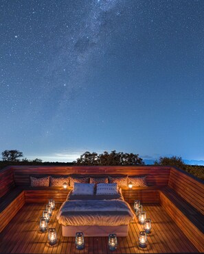 A starry night sky over a wooden deck with a bed and lanterns, surrounded by trees. - Oase by 7 Star Lodges - Greater Kruger Private 530ha Reserve (Hoedspruit)