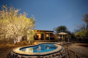 A swimming pool, a house, and a clear night sky. - Oase by 7 Star Lodges - Greater Kruger Private 530ha Reserve (Hoedspruit)