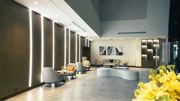 A modern lobby with a curved seating area, a large abstract painting on the wall, and a row of vertical light panels on the left wall. - Comfort Hotel Riyadh Olaya (Riyadh)