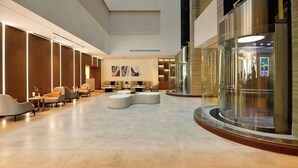 A spacious lobby with modern seating, a reception desk, and a glass elevator. - Comfort Hotel Riyadh Olaya (Riyadh)