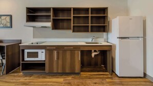 Eine kleine Küche mit Mikrowelle, Spüle und Kühlschrank.