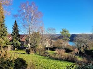 Un quartier résidentiel avec des maisons, un ciel d’un bleu éclatant et un lac en arrière-plan.