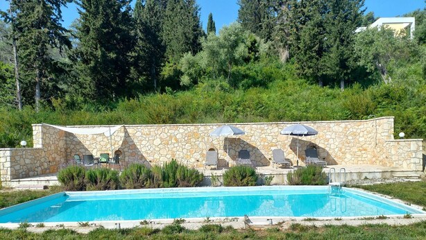 A swimming pool with stone walls and lounge chairs. - Wohlfühloase Inmitten Alter Oliven- und Zypressenbäumen (Karousades)