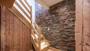 A wooden staircase with a stone wall. - Courchevel 1850, elegant, 3 bedrooms, 92sqm, ski in ski out, exceptional view (Courchevel)