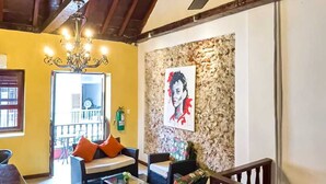 A cozy living room with a ceiling fan, a chandelier, and a fireplace. There is a staircase with a wooden railing leading to an upper level. - Casa Art Gallery, Cartagena Historic Center (Cartagena de Indias)