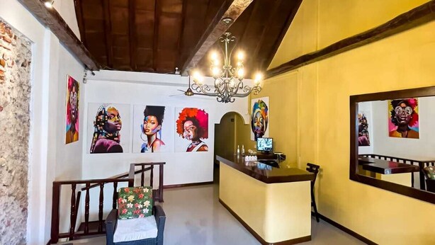 A spacious lobby with a high ceiling, a reception desk, and artwork on the walls. - Casa Art Gallery, Cartagena Historic Center (Cartagena de Indias)