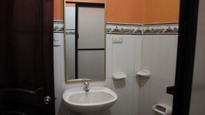 A bathroom with a white sink, a mirror, and a toilet. - macas center (Macas)