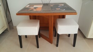 A small dining table with a wooden top and two white cushioned chairs. - Large studio in a Provençal house (Cagnes-sur-Mer)