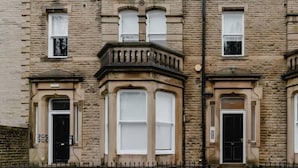 A row of terraced houses with bay windows and a black metal fence in front. - Apt 3 Prescott Court Halifax (Halifax)
