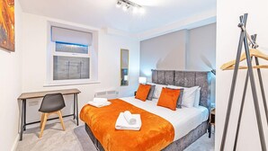 Une chambre d’hôtel moderne avec un grand lit, un bureau et une chaise.
