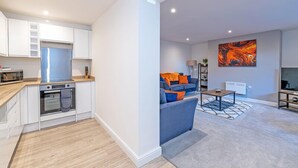 Un appartement moderne comprenant une cuisine, un salon et un grand tableau accroché au mur.