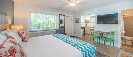 A bedroom with a bed, a desk, and a chair.