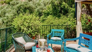 An outdoor seating area with blue furniture, a table with drinks, and a view of a mountainous landscape. - VILLA OASI - Four Bedroom Villa, Sleeps 8 (Positano)
