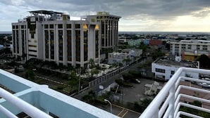 A multi-story building with a central courtyard, surrounded by smaller buildings and a clear view of the cityscape.
