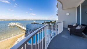Een balkon met een zwembad, met uitzicht op een jachthaven en een waterpartij.