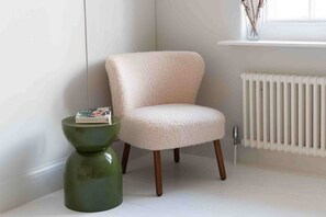A room with a white radiator, a green side table, and a fluffy chair. - Open plan Chelsea apt for 2 nr King’s Road (London)