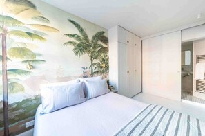 A bedroom with a bed, a wardrobe, and a bathroom visible through an open door.