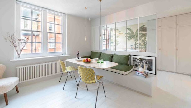 A modern kitchen with a dining table, chairs, and a built-in bench. - Open plan Chelsea apt for 2 nr King’s Road (London)