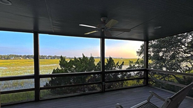 A covered porch with a ceiling fan, wooden flooring, and a view of a water body and fields. - Marsh view double decker ultimate privacy off the main paths. 862 Fiddlers Ridge (Fripp Island)
