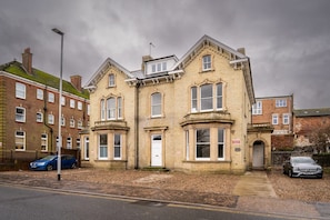 A two-story building with a symmetrical facade, large windows, and a prominent entrance. - Japanese Style maisonette 2BR (Norfolk)