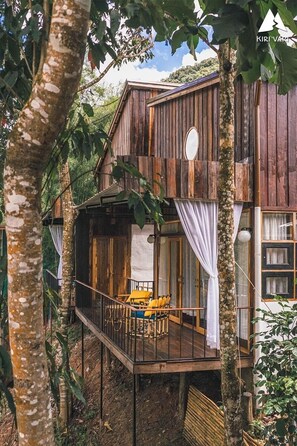 A wooden cabin with a balcony, surrounded by trees. - Kiri Vari Boutique Resort (Bo Kluea)