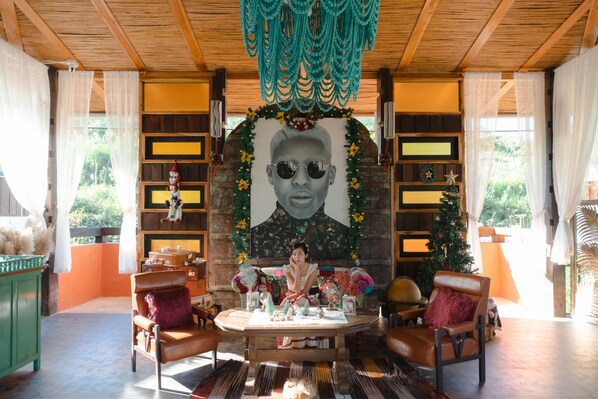 A cozy room with a wooden ceiling, a large portrait on the wall, and a Christmas tree.