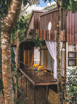 A wooden cabin with a balcony, surrounded by trees. - Kiri Vari Boutique Resort (Bo Kluea)