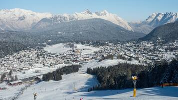 Eine verschneite Bergstadt mit Skipisten und freiem Blick auf die umliegenden Gipfel.