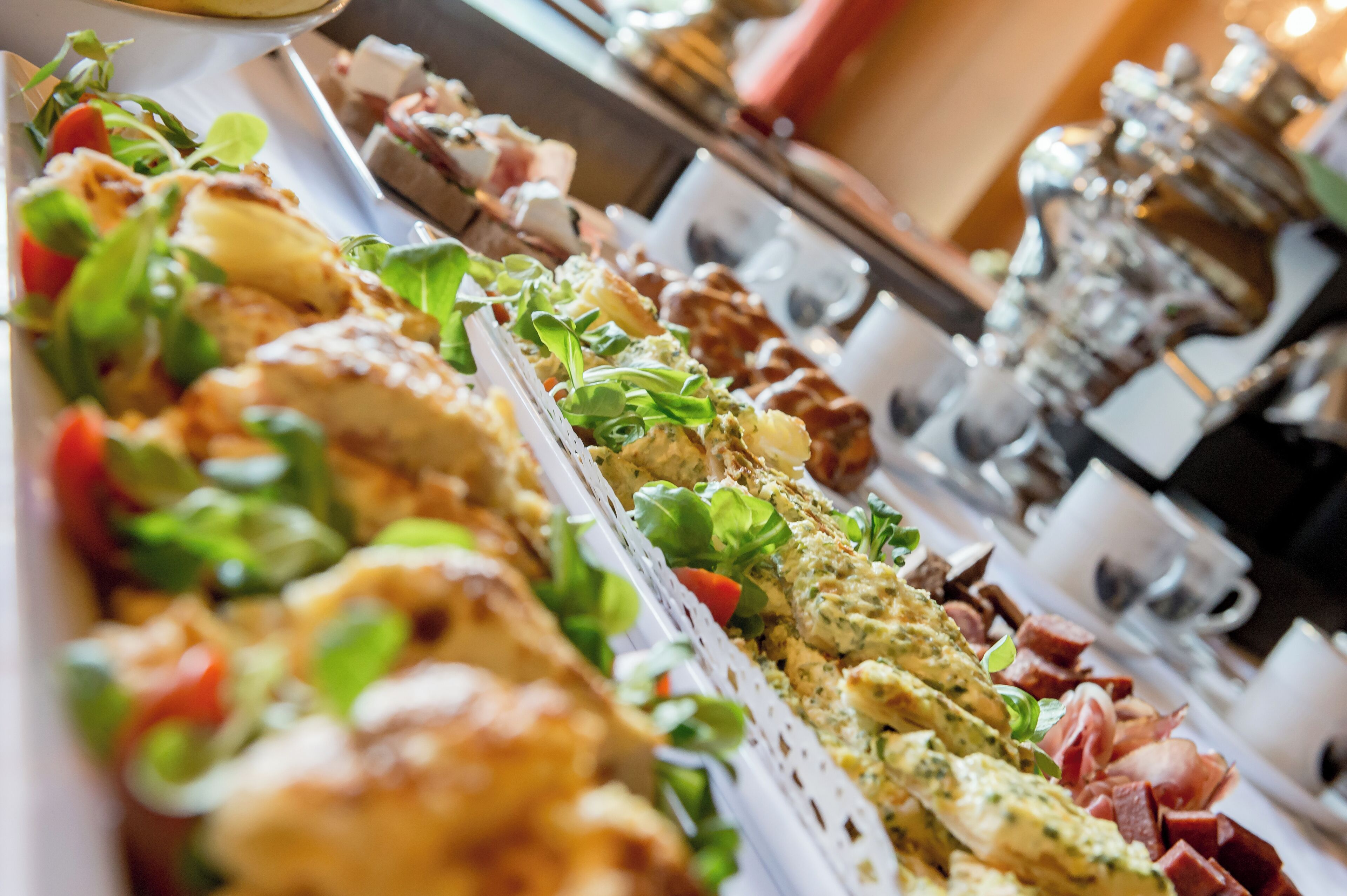 A buffet with various dishes including salads, meats, and possibly some seafood.