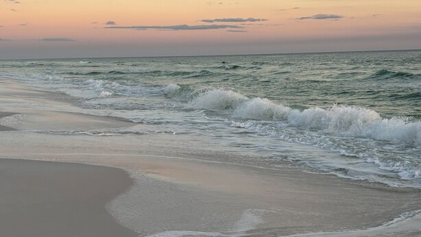 A beach with waves gently lapping onto the shore.