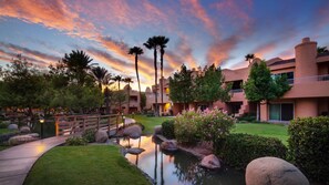 Stroll through the resort's beautifully maintained garden, featuring a tranquil pond and paved walkway.