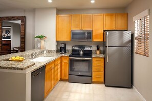 Enjoy cooking in this well-equipped kitchen with a granite countertop, stainless steel appliances, and a dishwasher.