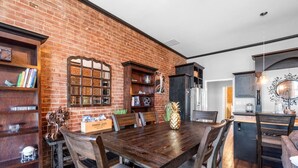 Ein Essbereich mit Backsteinwand, Holzmöbeln und einer Ananas als Mittelpunkt.