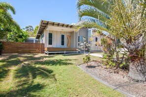 A modern house with a flat roof, large windows, and a well-maintained lawn. - Recovery On Discovery Holiday House (Agnes Water)