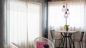 Een eetruimte met een houten plafond, een tafel met stoelen en een hanglamp.
